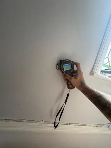 Moisture meter reading 187 REL in the entrance hallway