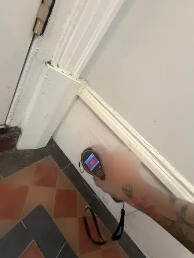 Moisture meter reading 955 REL in the entrance hallway