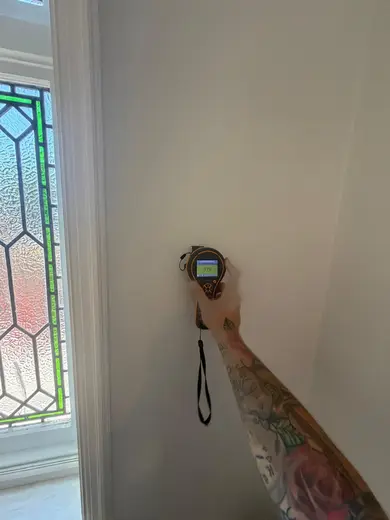 Moisture meter reading 179 REL in the entrance hallway